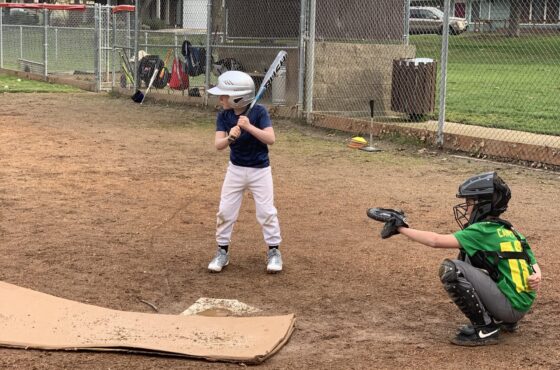 Little league baseball game with a player at bat