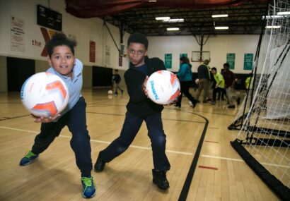 Two kids playing with new soccer balls