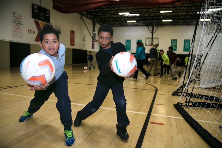 Two kids playing with new soccer balls