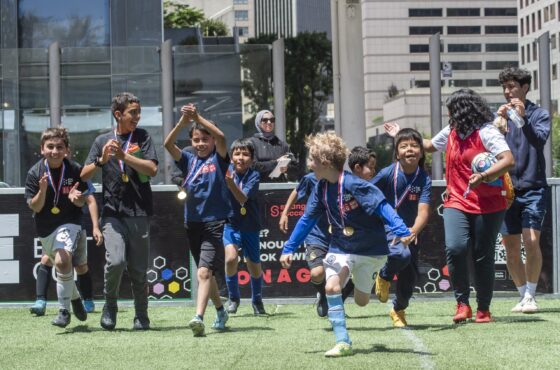 Young boys with medals running on soccer field