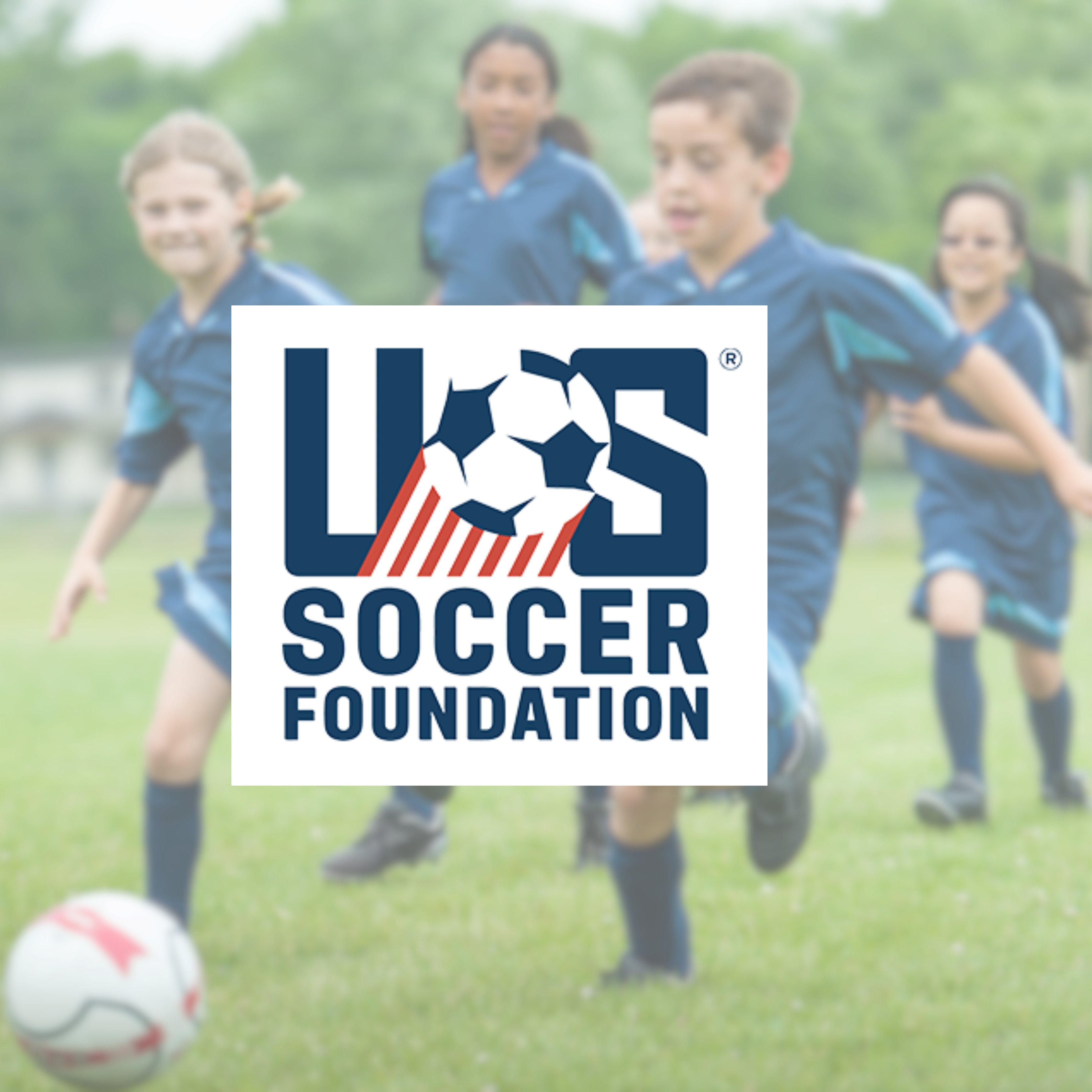 US Soccer Foundation logo with blurred background of kids playing soccer